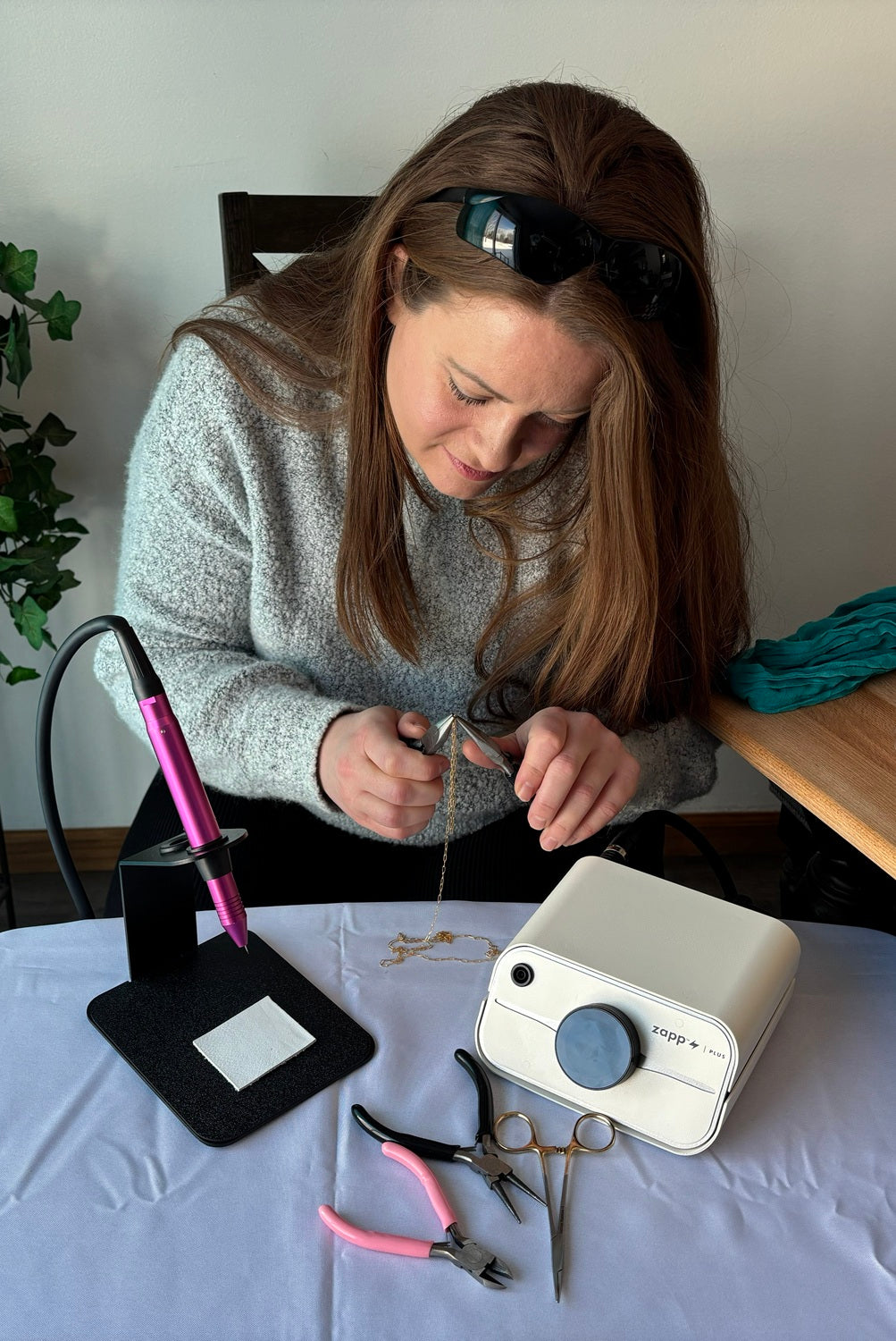 Trinity using a permanent jewelry kit to weld jewelry